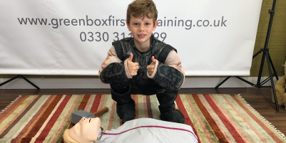 child giving thumbs up in a first aid course class